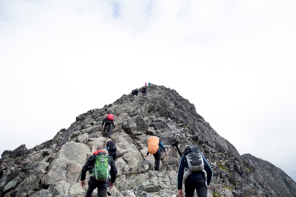 Several people climb the rocky peak